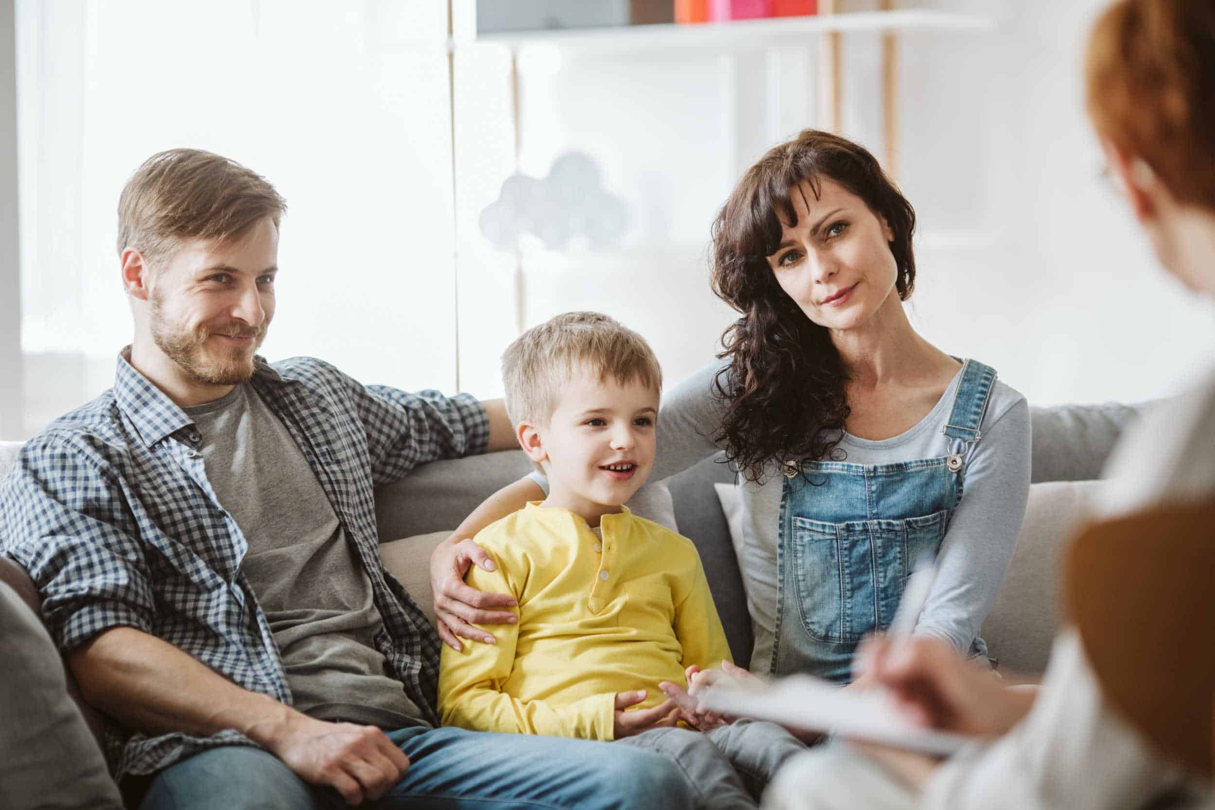 Happy Child on Sofa with Parents