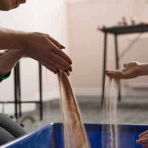 view of therapist and child working with sand as part of a play therapy session