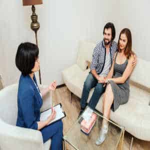 Therapist in discussion with couple on couch