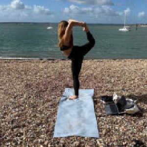 Woman in yoga pose on beach