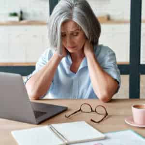 Mature woman at desk looking frustrated