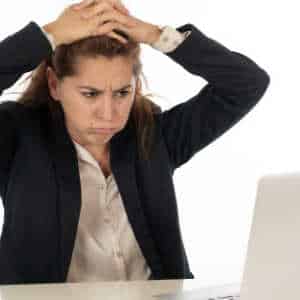 frustrated young female employee looking at PC 