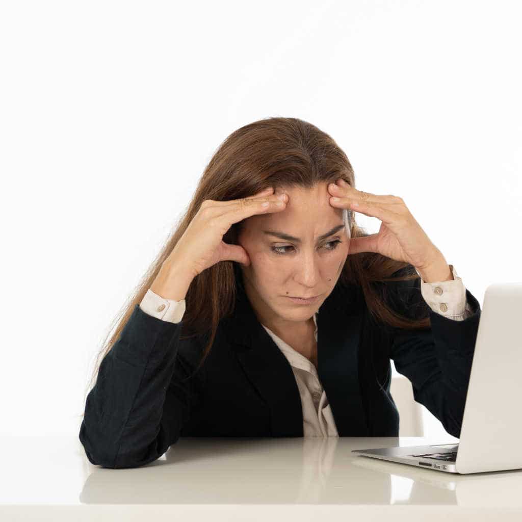 Stressed female worker with head in hands
