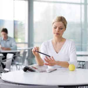 female worker sitting alone in office canteen
