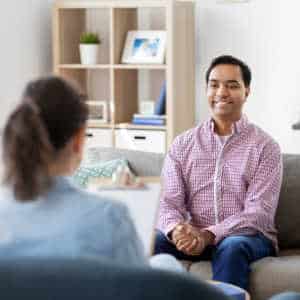 Therapist with male client looking happy